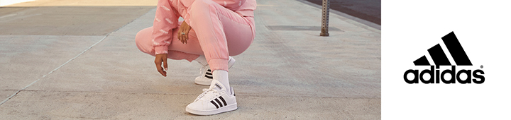 Adidas wird von Frau in sportlichem Outfit in einer Stadt getragen.